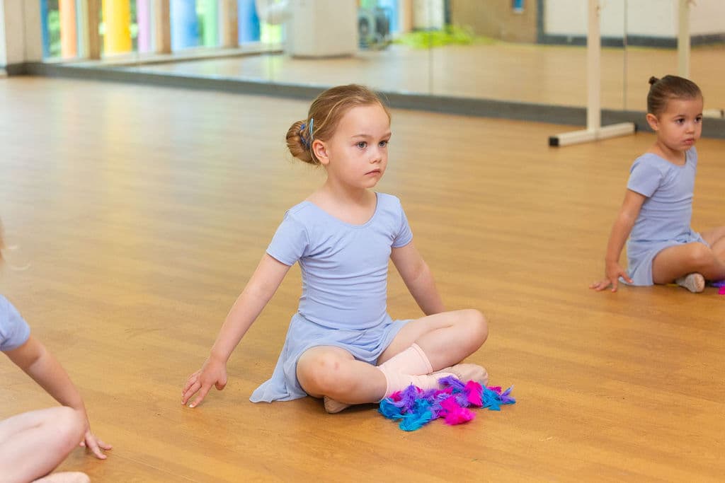 Young dancers sitting together in a ballet class at En Pointe Theatre Arts