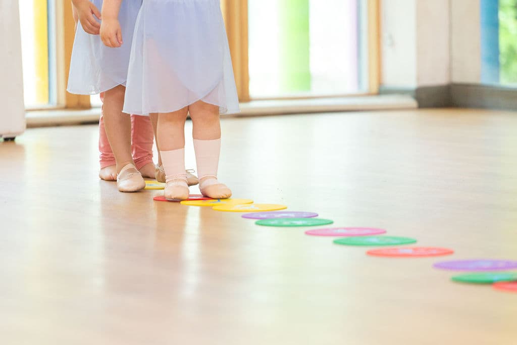 Tiny Ballet dancers standing on colourful floor spots at En Pointe Cardiff